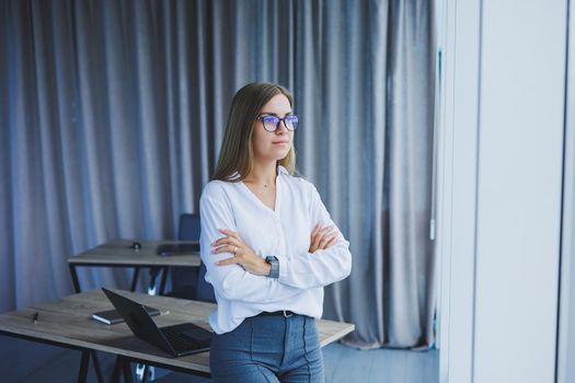 Business woman in the office with glasses in her hands. Woman manager in glasses and white shirt in the office. Working day manager