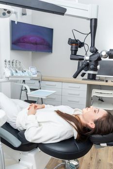 Female patient laying in dental chair befor treating. Medicine, dentistry and health care concept