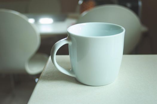 White empty mug standing on the kitchen counter