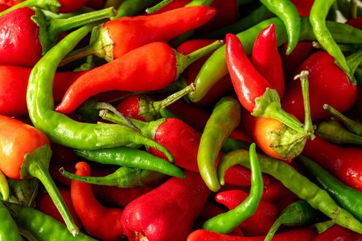 Organic fresh red and green hot peppers in wooden bowl