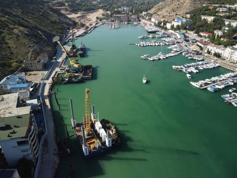 Aerial above Balaclava picturesque bay Crimea Sevastopol ancient resort city tourist attraction. Many yacht ships dock sail.