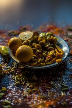 Close up shot of traditional ivy gourd or tindora salad in a glass plate with all of its constituent ingredients with it on a brown colored wooden surface.