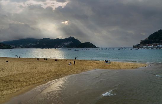 Landscape of La Concha beach in the city of San Sebastian, in the Spanish Basque Country, on a cloudy day at sunset with Mount Igueldo in the background.