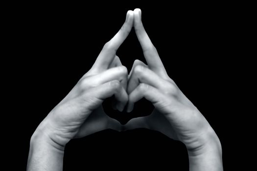 Shot of male hands isolated on black background demonstrating Kalesvara mudra.