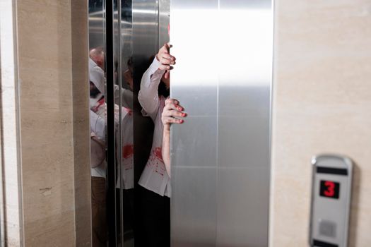 Couple of angry zombies escaping elevator, attacking startup office to attack people with horrific violence. Abusive undead scary monsters eating brain, looking terrifying and cruel.