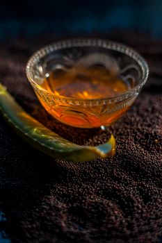 Mustard seed face mask for glowing skin. Shot of face mask ingredients which are mustard seeds, aloe vera, and some honey in a glass bowl on a black surface.