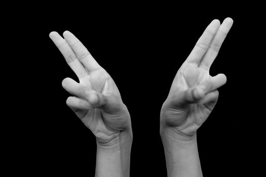 Shot of pair of hands doing Kapitthaka Mudra or Smiling Buddha Mudra isolated on black background.