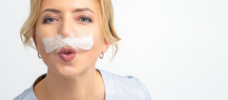 Funny beautician with a white feather-like mustache poses on white background, depilation concept