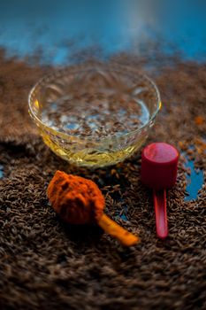 DIY Face mask for smooth and glowing skin. Shot of cumin seeds along with some turmeric on a brown surface making a glowing skin face mask all together.