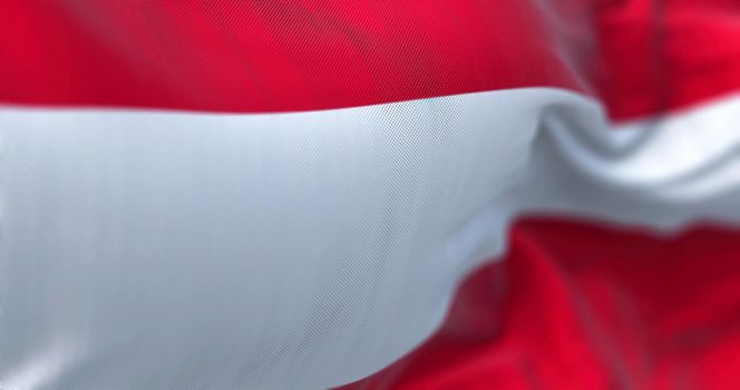 Close-up view of the austrian national flag waving in the wind. Austria is a landlocked country in the southern part of Central Europe. Fabric textured background. Selective focus