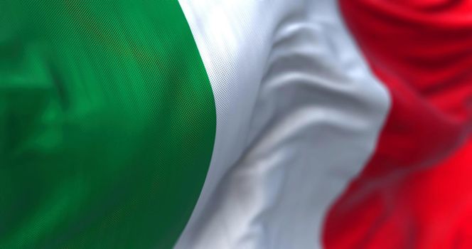 Close-up view of the italian national flag waving in the wind. Italy is a country located in the middle of the Mediterranean Sea, in Southern Europe. Fabric textured background. Selective focus