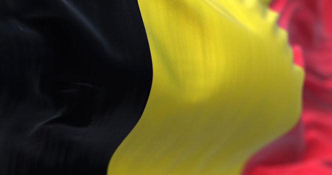 Close-up view of the belgian national flag waving in the wind. Belgium is a country in Northwestern Europe. Fabric textured background. Selective focus