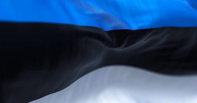 Close-up view of the estonian national flag waving in the wind. Estonia is a country in Northern Europe. Fabric textured background. Selective focus