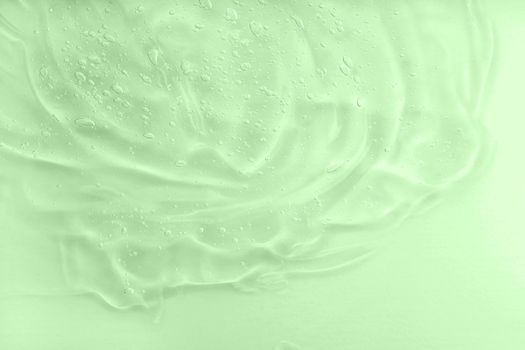 Aloe vera cosmetic gel texture with bubbles background. Skincare moisturizing product. Liquid green oil smudge. The concept of natural cosmetics. Hyaluronic acid clear serum sample. Close-up, macro.