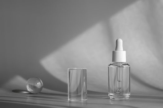 Glass cosmetic bottle, serum with peptides and retinol product packaging and modern acrylic transparent geometric shapes decor with shadows from sun, cosmetic mockup, skincare concept. Packaging front