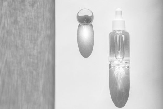 Transparent liquid product packaging in glass bottle. Hyaluronic acid oil mockup. Anti aging serum with collagen and peptides on white surface with sunlight and shadow. Flat lay, top view, copy space