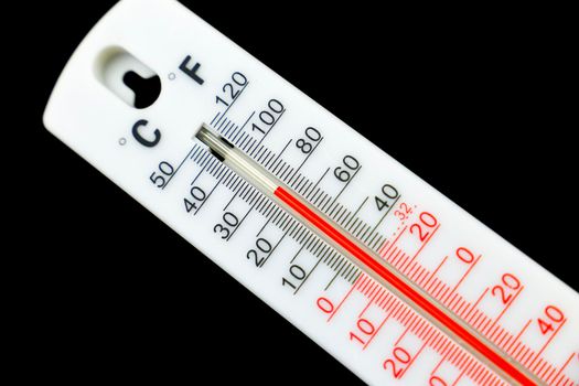 26 Celsius and 80 Fahrenheit degrees on a thermometer on black background