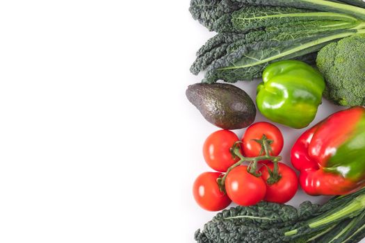 Fresh vegetables frame. Black kale leaves, tomatoes branch, red and green bell pepper, avocado. Delicious raw vegetable food mockup. Concept of healthy food. Top view, flat lay, copy space.