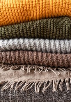 Hello fall. Cozy warm image. Stack of colorful autumn warm sweaters