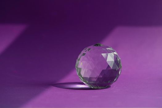 Crystal prism refracting light, magic crystals and pyramid, sphere and cube on purple background. Spiritual healing crystal practice. Feng Shui, good energy flow concept, esoteric background..