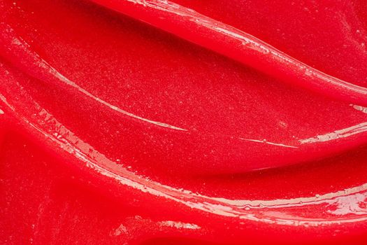 Red gel texture. Cosmetic clear liquid cream smudge. Skin care product sample closeup. Toothpaste or wax background