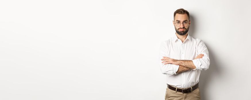 Disappointed businessman pouting, standing displeased against white background. Copy space