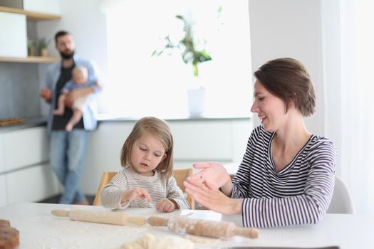 Happy parents playing with their children in the kitchen