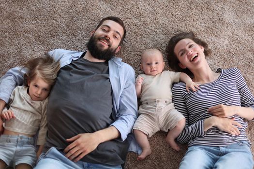 happy family mother father and kids at home. laying