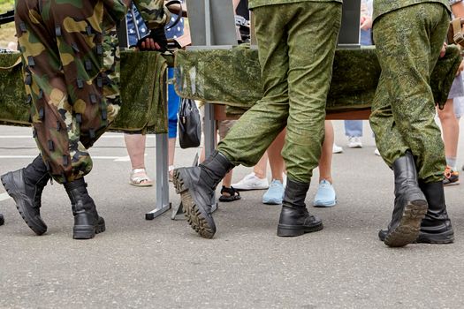 the military stand in camouflage with their backs in boots. feet of dirty soldiers