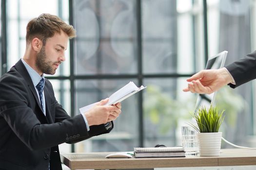 Businessman Taking Papers From Secretary In Office