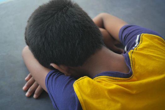 teenage boy head down on desk .