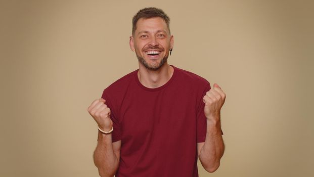 Oh my God, Wow. Excited amazed man looking surprised at camera with big eyes, shocked by sudden victory game winning, lottery goal achievemen, good news. Adult guy on beige studio background indoor