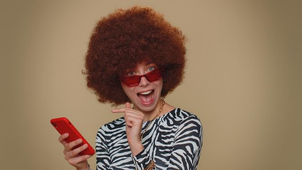 Pretty young female girl using smartphone typing new post on web, browsing, searching, addiction of social networks, show thumbs up like, positive feedback, recommends wifi cellular connection 5G