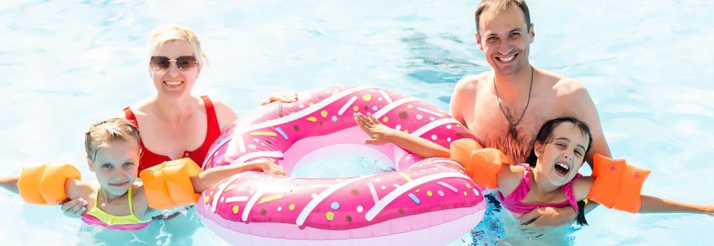 Beautiful family having fun in a swimming pool.