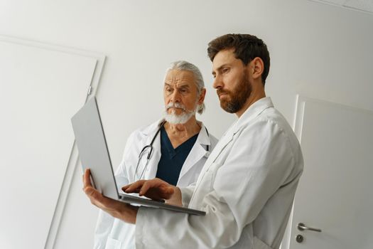 Two doctors are looking at something on the laptop in the doctor's office. High quality photo