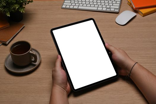 Close up man holding mock up digital tablet with blank screen.