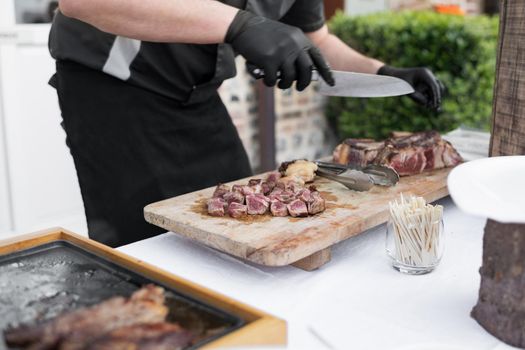 A chef cooks the veal at a plancha