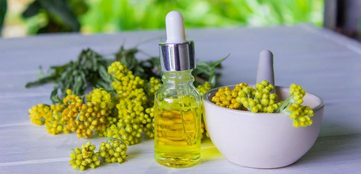essential oil of tansy in a beautiful bottle on the table. selective focus
