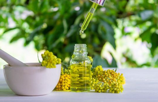 essential oil of tansy in a beautiful bottle on the table. selective focus