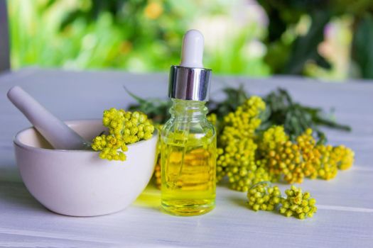 essential oil of tansy in a beautiful bottle on the table. selective focus