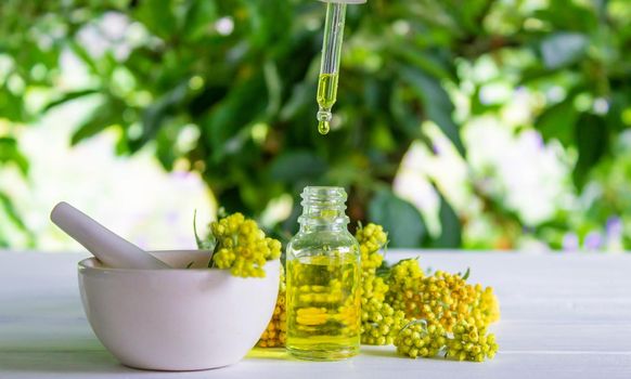 essential oil of tansy in a beautiful bottle on the table. selective focus