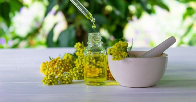 essential oil of tansy in a beautiful bottle on the table. selective focus