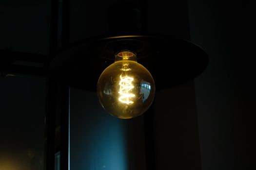 Retro-style light bulb glows in the dark close up