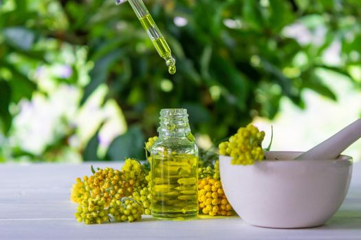 essential oil of tansy in a beautiful bottle on the table. selective focus