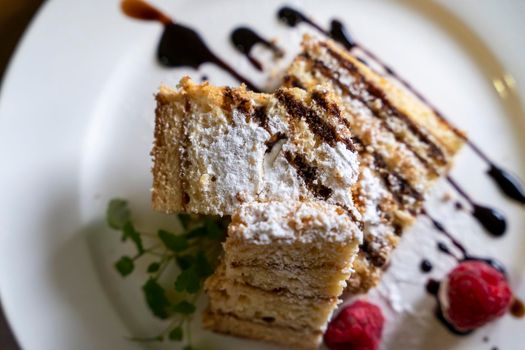 a delicious beautiful piece of cake with chocolate and berries on a white plate. culinary delights