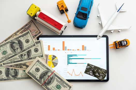 different types of toy cars and a tablet, money.