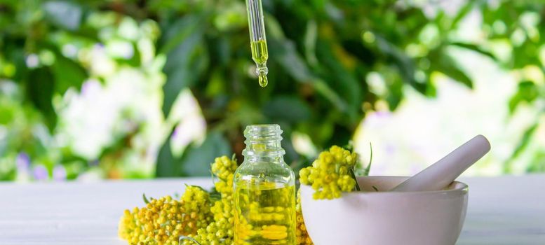 essential oil of tansy in a beautiful bottle on the table. selective focus