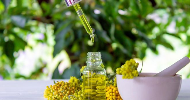 essential oil of tansy in a beautiful bottle on the table. selective focus