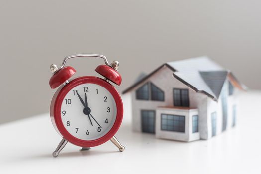 Toy House and alarm clock isolated on white