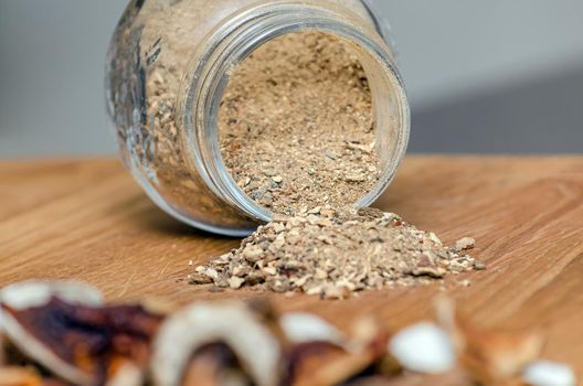 dried mushrooms on spread out on a wooden table. Chopped boletus in a container. Copy space